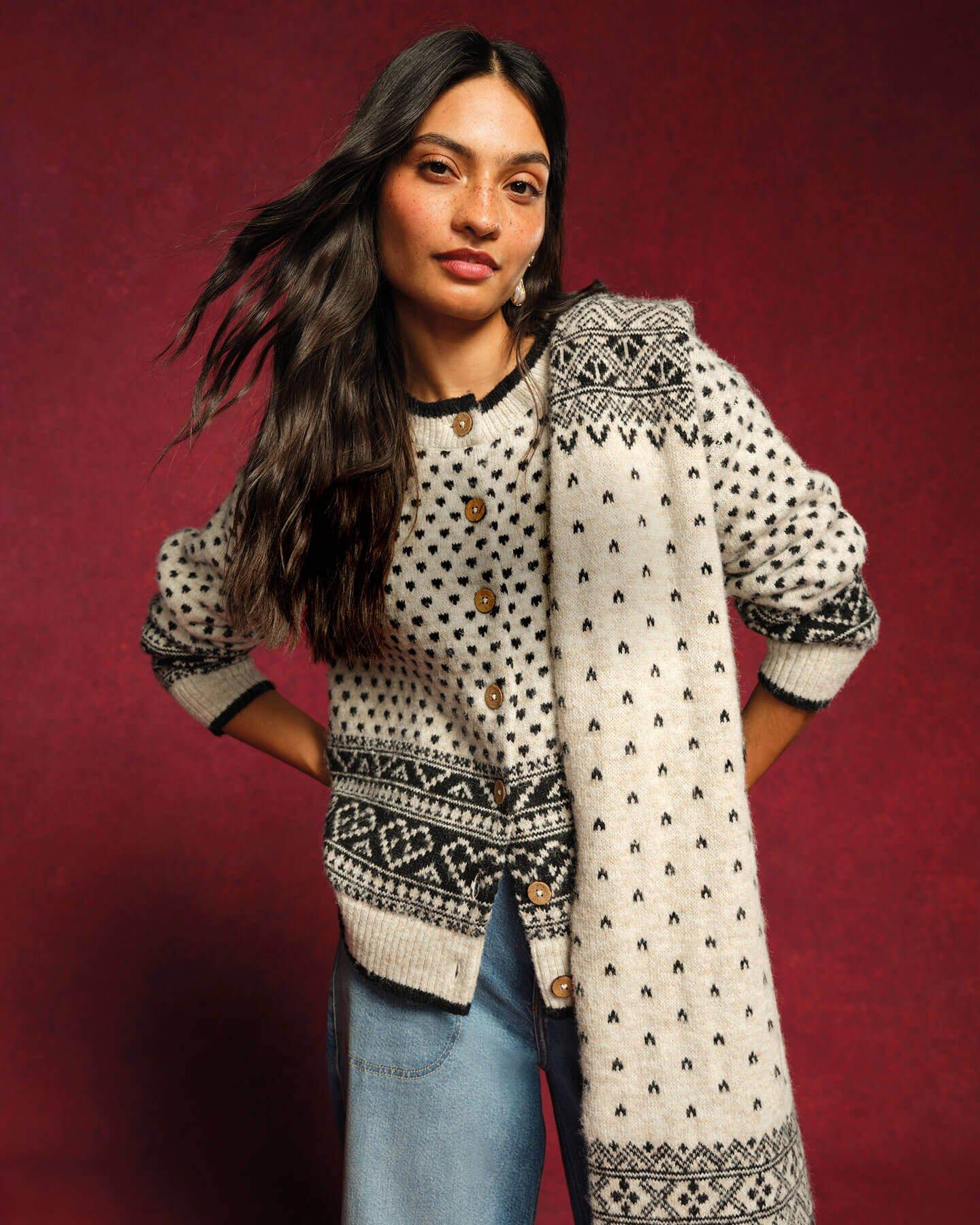 a female model wearing a matching black and white printed cardigan and scarf with a pair of light denim jeans